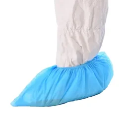 Non woven cleanroom polypropylene shoe cover, blue in colour, being worn on the foot of a cleanroom operative wearing a cleanroom coverall